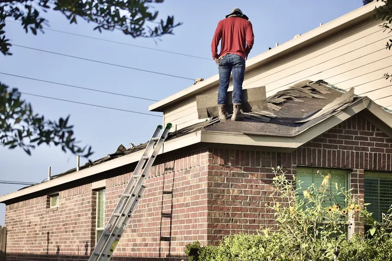 Professional roofer working on a residential roof in Greenawald